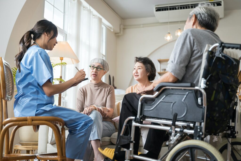 Senior people sit in a circle in an assisted living facility and listen to nurse during a group therapy